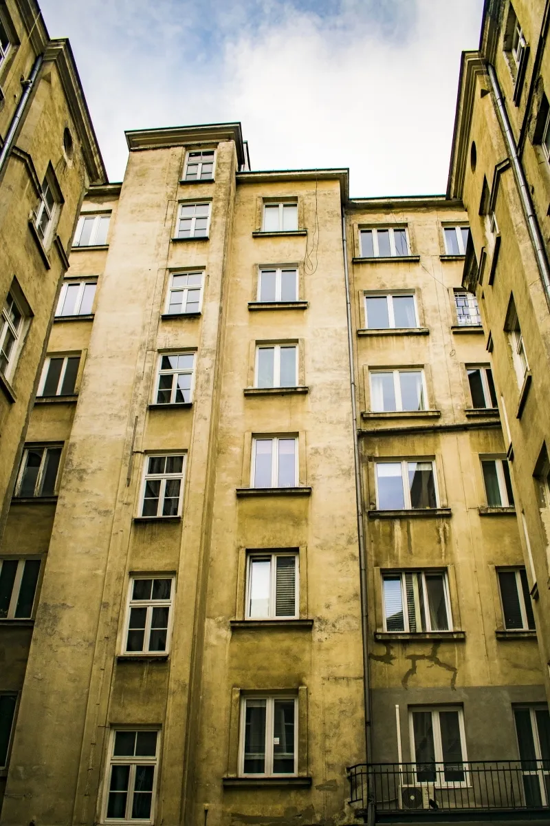 Tall weathered courtyard facade with stacked windows